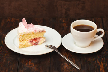 Cake slice and coffee cup on wooden background