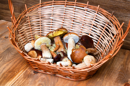 Fresh mushrooms in basket on wooden table