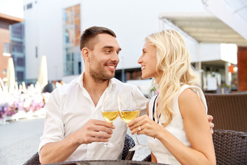 happy couple drinking wine at open-air restaurant