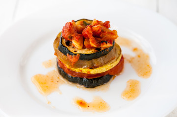 A white plate with ratatouille