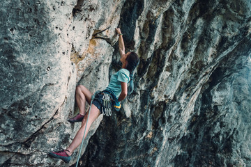Woman climbing the rock wall