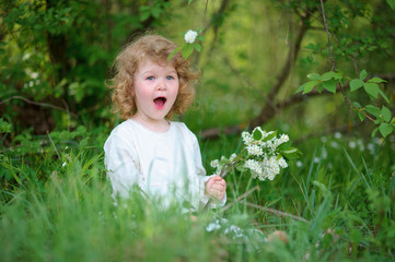 little girl wearing stylish white dress sitting in the grass. Su