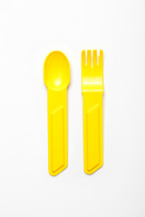 yellow plastic fork and spoon isolated on white background