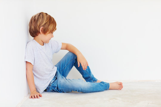 cute boy, kid sitting near the wall