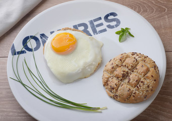Scrambled eggs sunny side up on bread. Breakfast on a white plate.