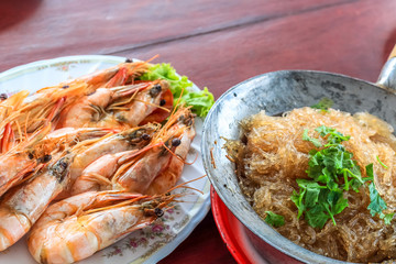 Top view steamed shrimp/prawn in the white plate and shrimps vermicelli  with glass noodles in hot pot ready to eat