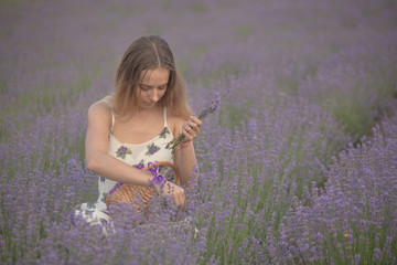 Smiling girl sniffing flowers in a lavender field