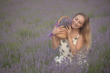 Smiling girl sniffing flowers in a lavender field