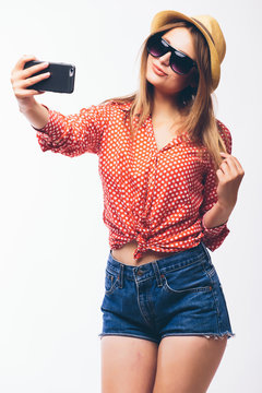 Happy cute woman making selfie over white background.