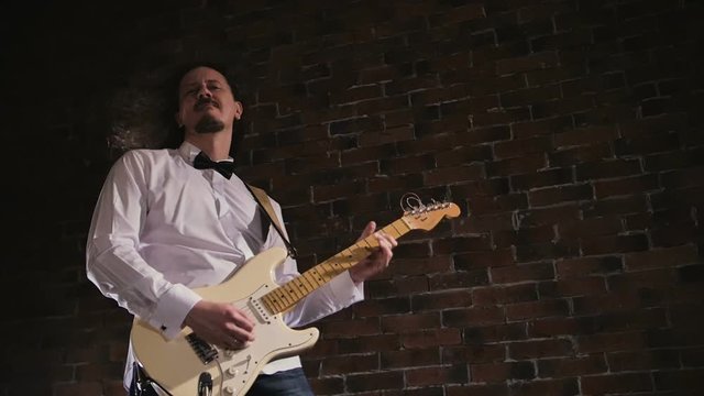 Man plays the guitar. Concert rock band performing on stage. Slow motion instrument playing