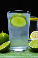 Glass with cold sparkling mineral water, lime and lemon