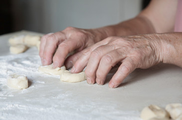 female hands crumple pieces of dough