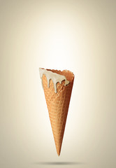 Empty waffle cone with a melting ice cream cone with edge