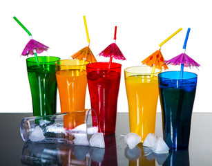 colored glasses with cocktails and ice cubes on a white backgrou