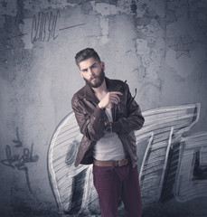 Fashion model standing at graffiti wall