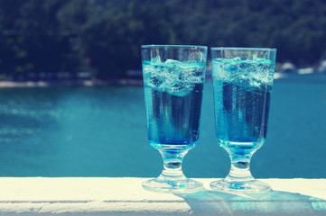 Blue Curacao cocktail. Two glasses of Blue Curacao cocktail against the sea.