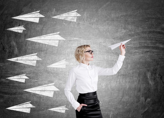 Blond woman holding paper plane