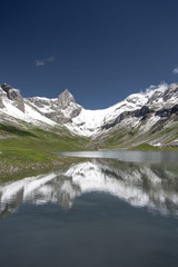 Fototapeta na wymiar High mountains reflection in splendid Glattalpsee lake on a lovely summer day, Swiss Alps, Schwyz Canton