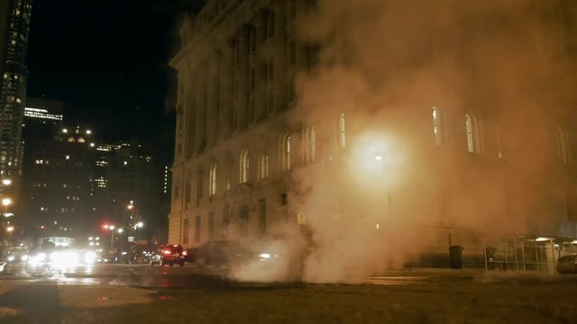 steam over street in new york city at night. traffic lights. urban background