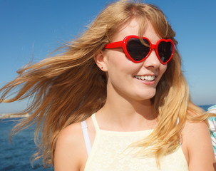 Girl in red sunglasses relaxing on sea coast.