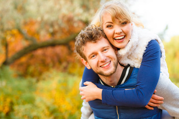 Man giving piggyback ride to woman in park