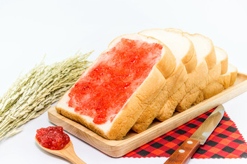sliced bread with a strawberry jam on wood plate