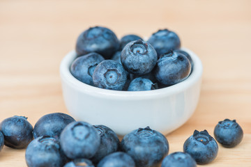 Blueberry in a bowl on wooden table background