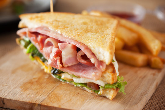 bacon and ham sandwich on wooden board