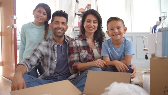 Portrait Of Hispanic Family Moving Into New Home 