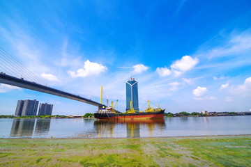 Cargo ship entering port of Bangkok, passing under the Bridge