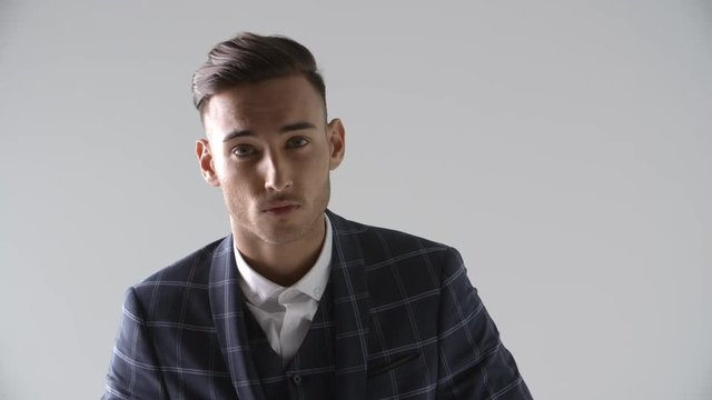 Young man runs hand through hair, turns, head and shoulders