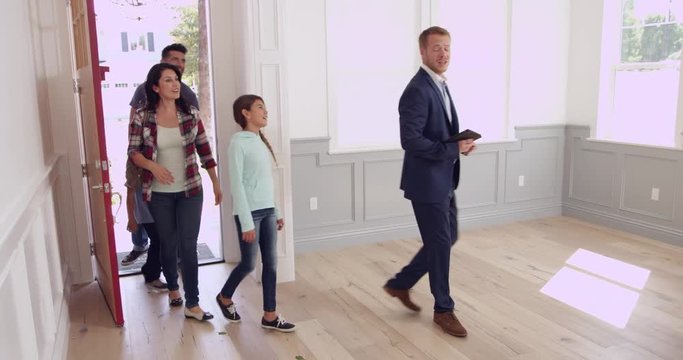 Realtor Showing Family Around New Home 