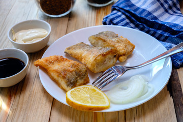 Fish fried in batter on a white plate