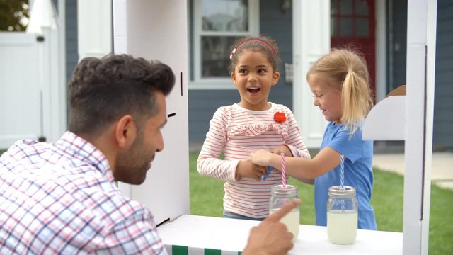 Father Buying Lemonade From Children's Stall  