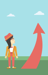 Business woman looking at arrow going up.