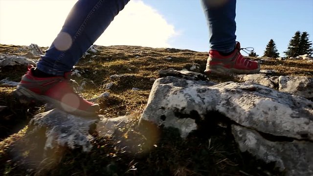 female hiker walking on rocky landscape. feet close up. sports activity