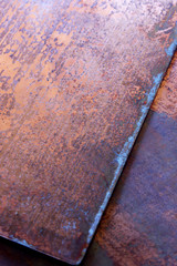 This is a closeup photograph of an old textured rusty copper plate