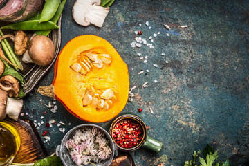 Pumpkin vegetarian cooking with mushrooms ,seasoning and spices, dark rustic background, top view, place for text
