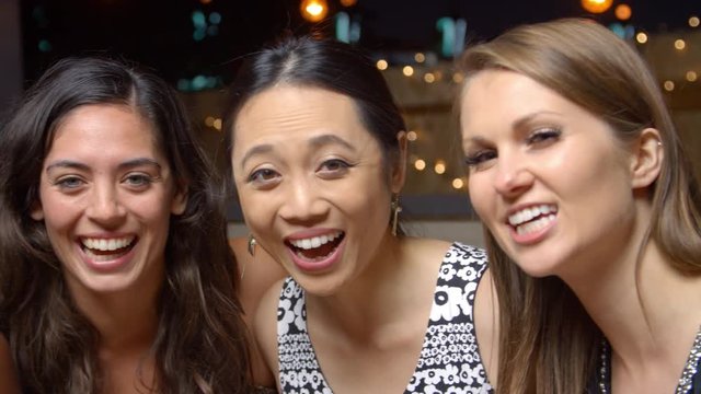 Female Friends Enjoying Night Out At Rooftop Bar, Slow Motion