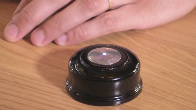 Man's hand pushes the call button and the LED on it flashes
