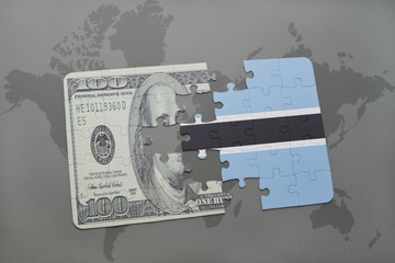 puzzle with the national flag of botswana and dollar banknote on a world map background.