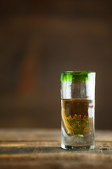 Gold tequila in glass on wood table. Selective Focus. Blurred background.