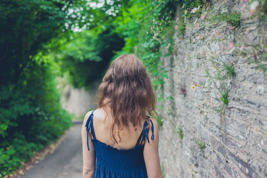 Young woman walking by wall in countryside