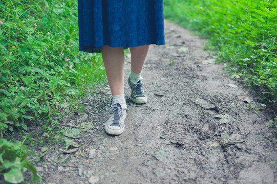 Feet and legs of woman walking in forest