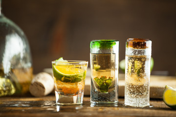 Shot glass of tequila on wood table. Selective focus. Blurred background.