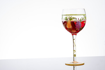 Glass of red wine on white background with flowers and copy spac