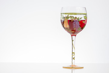 Glass of red wine on white background with flowers and copy space
