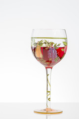 Glass of red wine on white background with flowers and copy space
