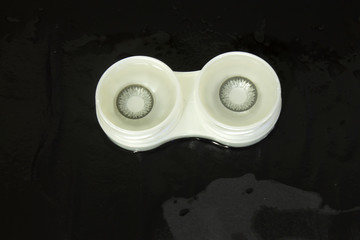 This is a photograph of Grey contact lenses placed in a case