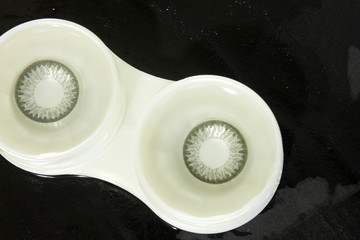 This is a photograph of Grey contact lenses placed in a case